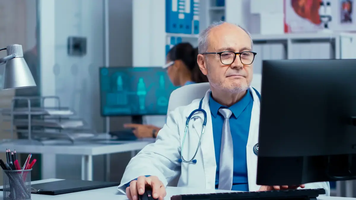 Elderly doctor working on pc